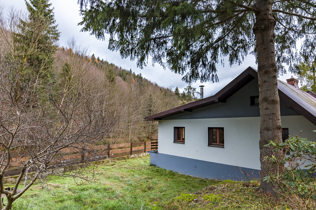 Drewniany dom położony nad wodą, otoczony lasem - ośrodek terapii uzależnień Śląsk Bezpieczna Przystań